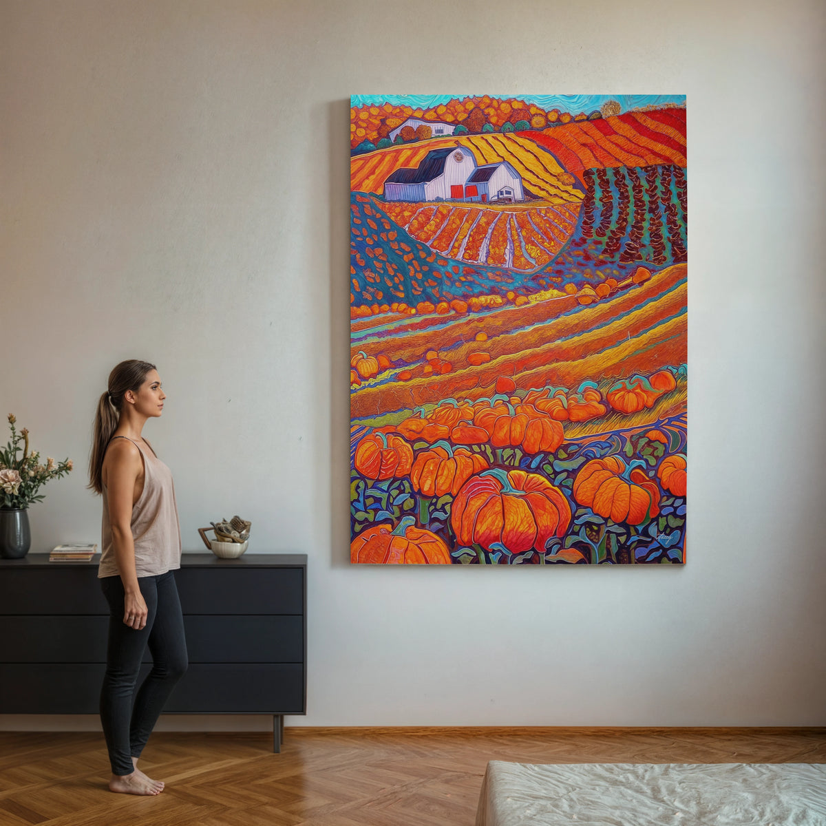 Woman standing in a room with a colorful painting of a pumpkin field on the wall.