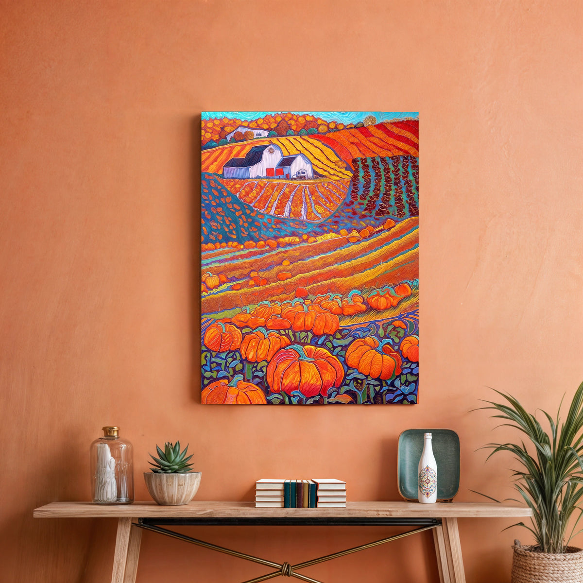 Colorful landscape painting with pumpkins on an orange wall above a wooden table.